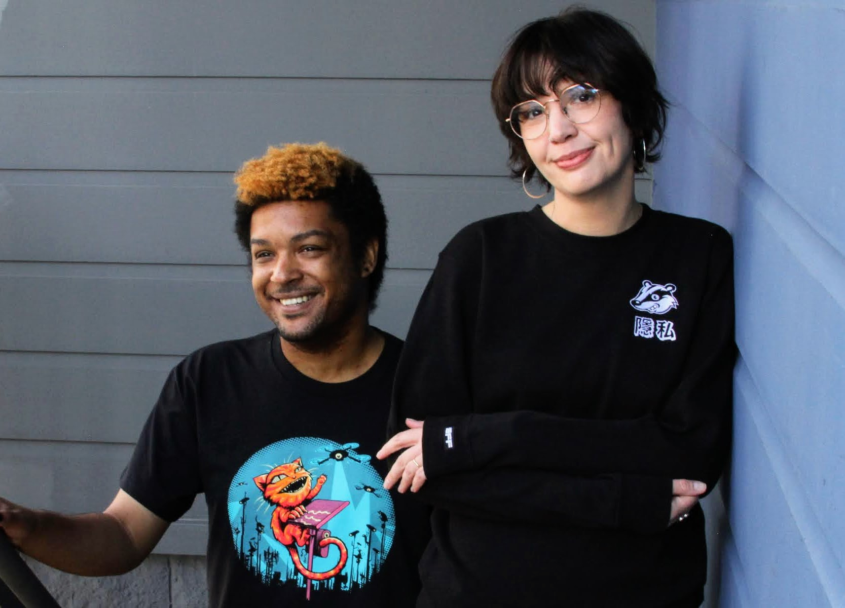 A person wears an EFF Claw Back member t-shirt on the left. A person on the right wears a black sweatshirt with the Privacy Badger mascot on the chest. A person wears an EFF Claw Back member t-shirt on the left. A person on the right wears a black sweatshirt with the Privacy Badger mascot on the chest.